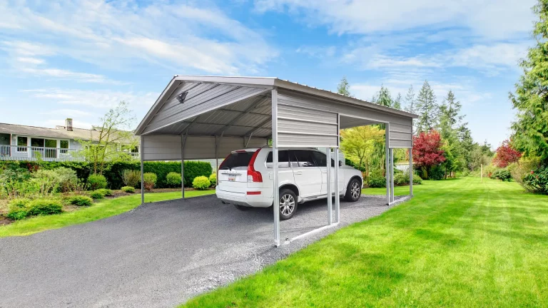 20x20x9 vertical roof metal carport with partial side panels, sheltering a white SUV on a gravel driveway. This durable metal carport offers reliable covered parking, and Eagle Carports has metal carports for sale to protect vehicles from rain, snow, and UV rays.