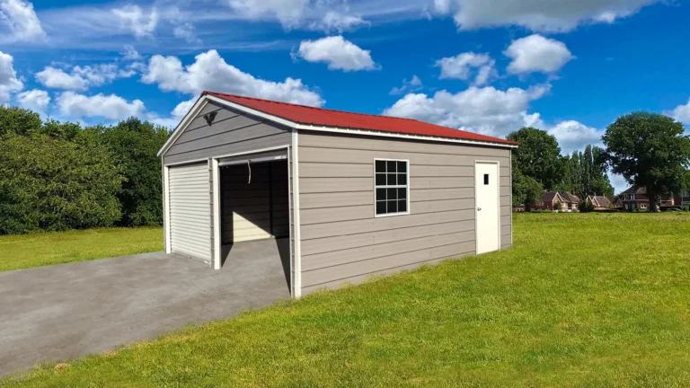 15x20x8 vertical roof metal garage with a red roof, roll-up door, side entry door, and window, providing secure storage on a grassy lot. This durable metal garage protects vehicles and equipment, and Eagle Carports offers metal garages for sale for all-weather protection.