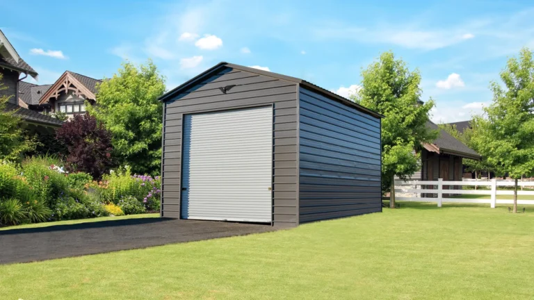 18x25x14 vertical roof metal garage with dark gray siding and a tall roll-up door, set on a manicured lawn beside a paved driveway. This high-clearance metal garage offers secure storage for vehicles and equipment, and Eagle Carports provides metal garages for sale to protect valuable property.