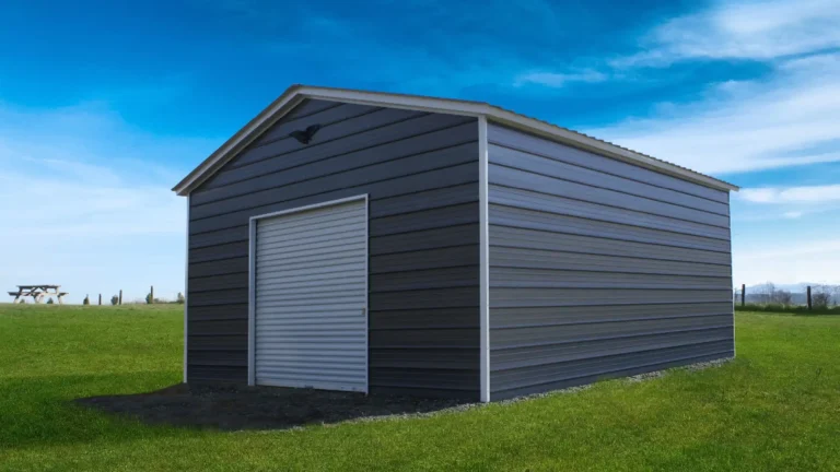 20x25x10 vertical roof metal garage with dark gray siding and a roll-up door on a grassy lot under a blue sky. This spacious metal garage provides secure storage for vehicles and equipment, and Eagle Carports offers metal garages for sale to protect your property from the elements.